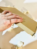 Picture of a hand holding the letterbox size giftbox that fits through a letterbox A5 size.